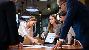 Marketing professionals reviewing campaign ideas and digital content during a team meeting.