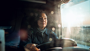 Transportation worker inspecting or maintaining a vehicle in a garage or service area.