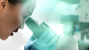 Scientist looking into a microscope.